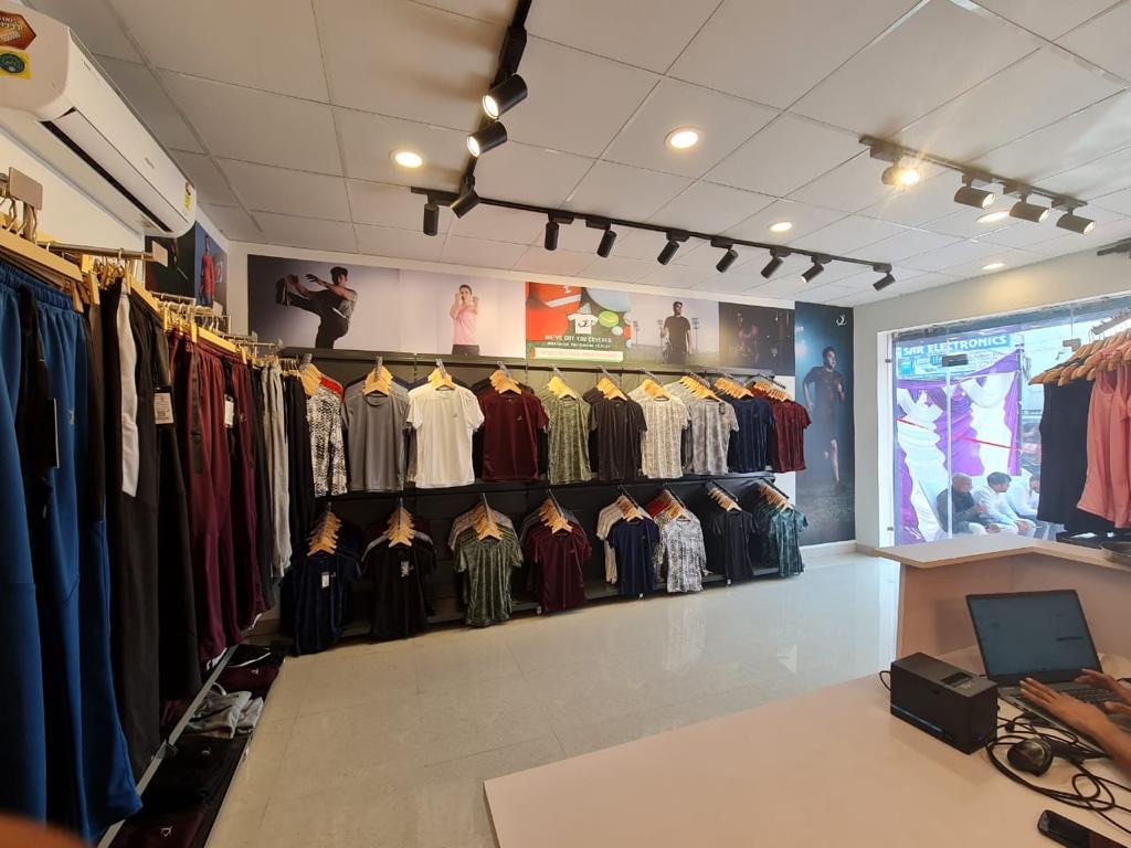 Clothing rails and wall display fixtures in a garment shop.